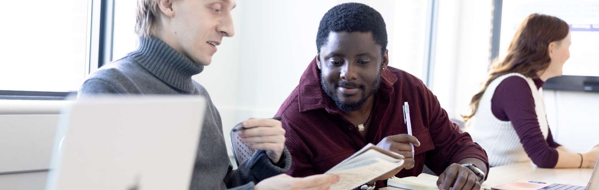 Two people looking at a notebook